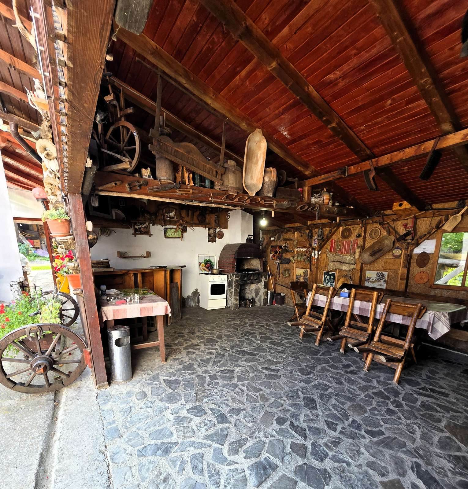 Salon rustic cu pardoseală de piatră și grinzi de lemn aparente