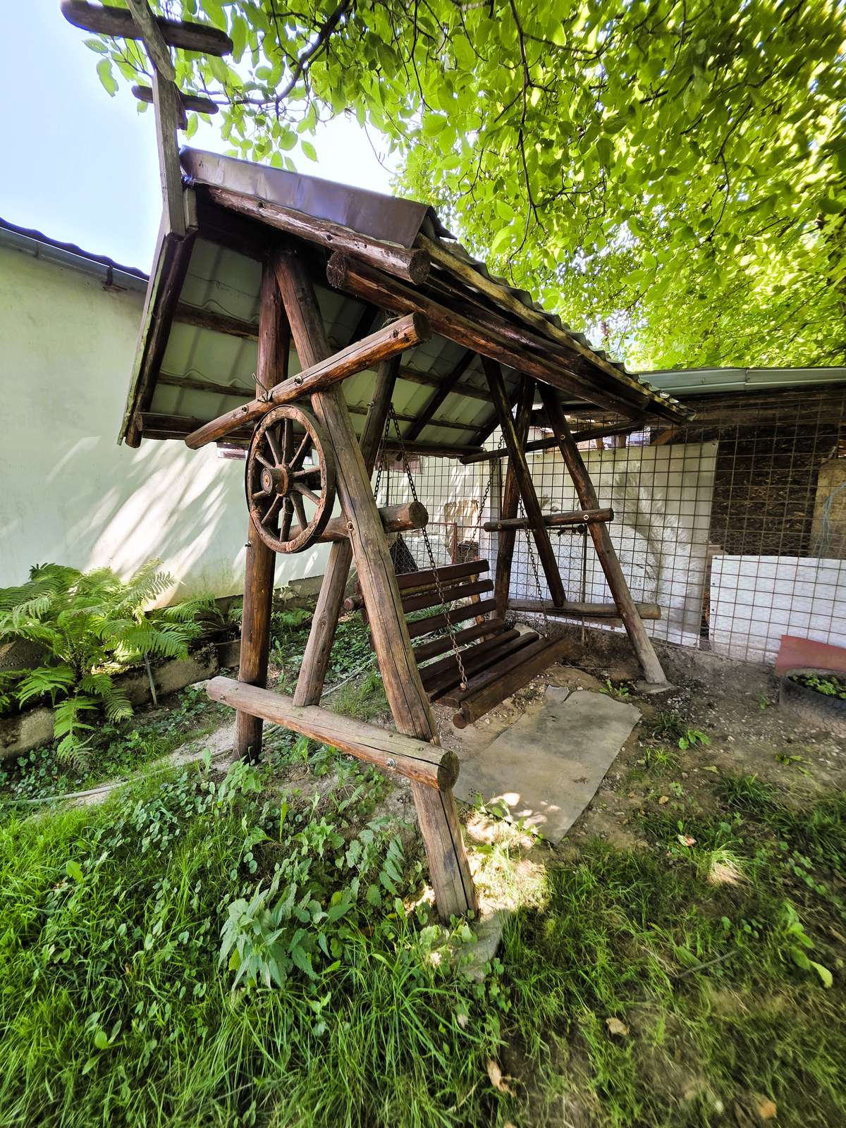 Foișor din lemn în grădina pensiunii, înconjurat de verdeață